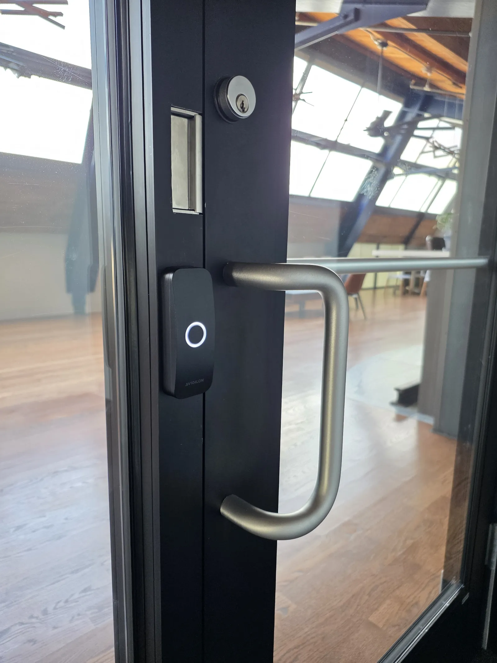 Avigilon Alta access reader installed on a glass entry door by INTEK