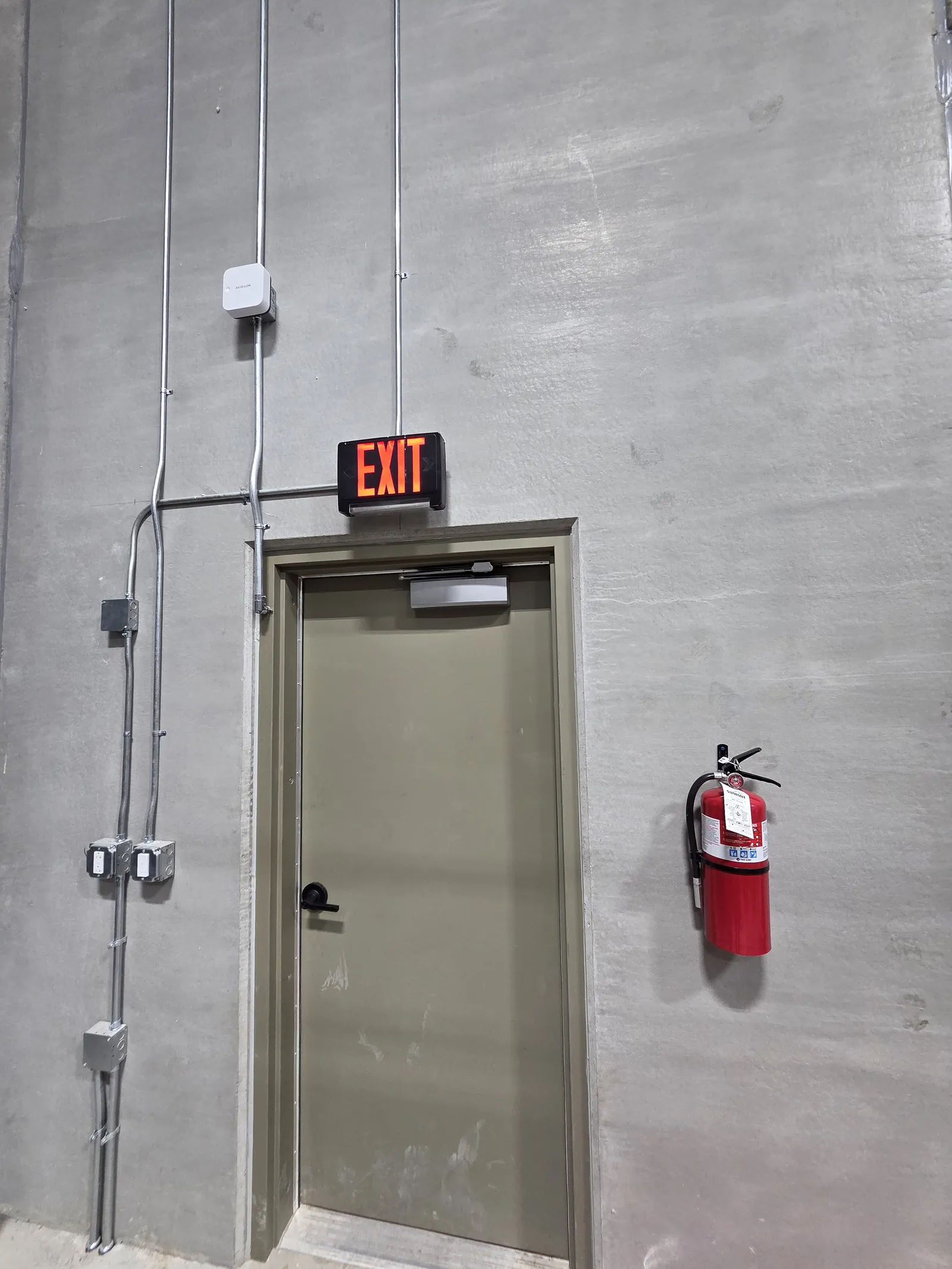 Secured door with Avigilon Alta Single Door Controller mounted above it and access wiring run in conduit by INTEK